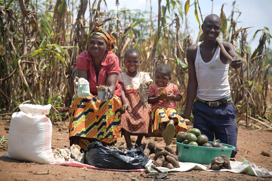 Image of young family in Africa with root vegetables
