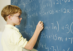Boy doing math at chalkboard