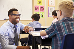 Image of smiling African American teacher with student