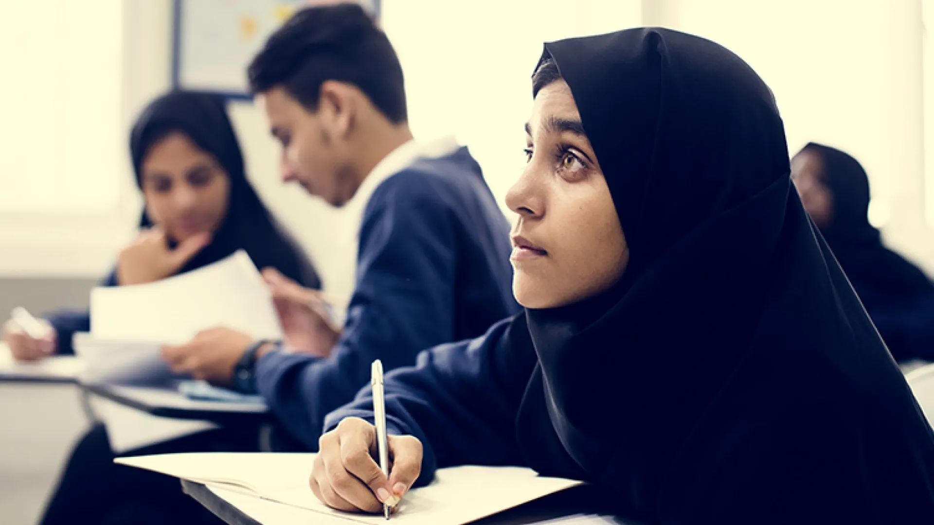 Student in hijab at school desk