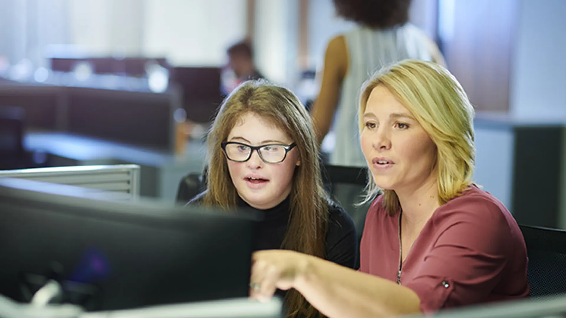 Visually impaired apprentice and mentor at computer
