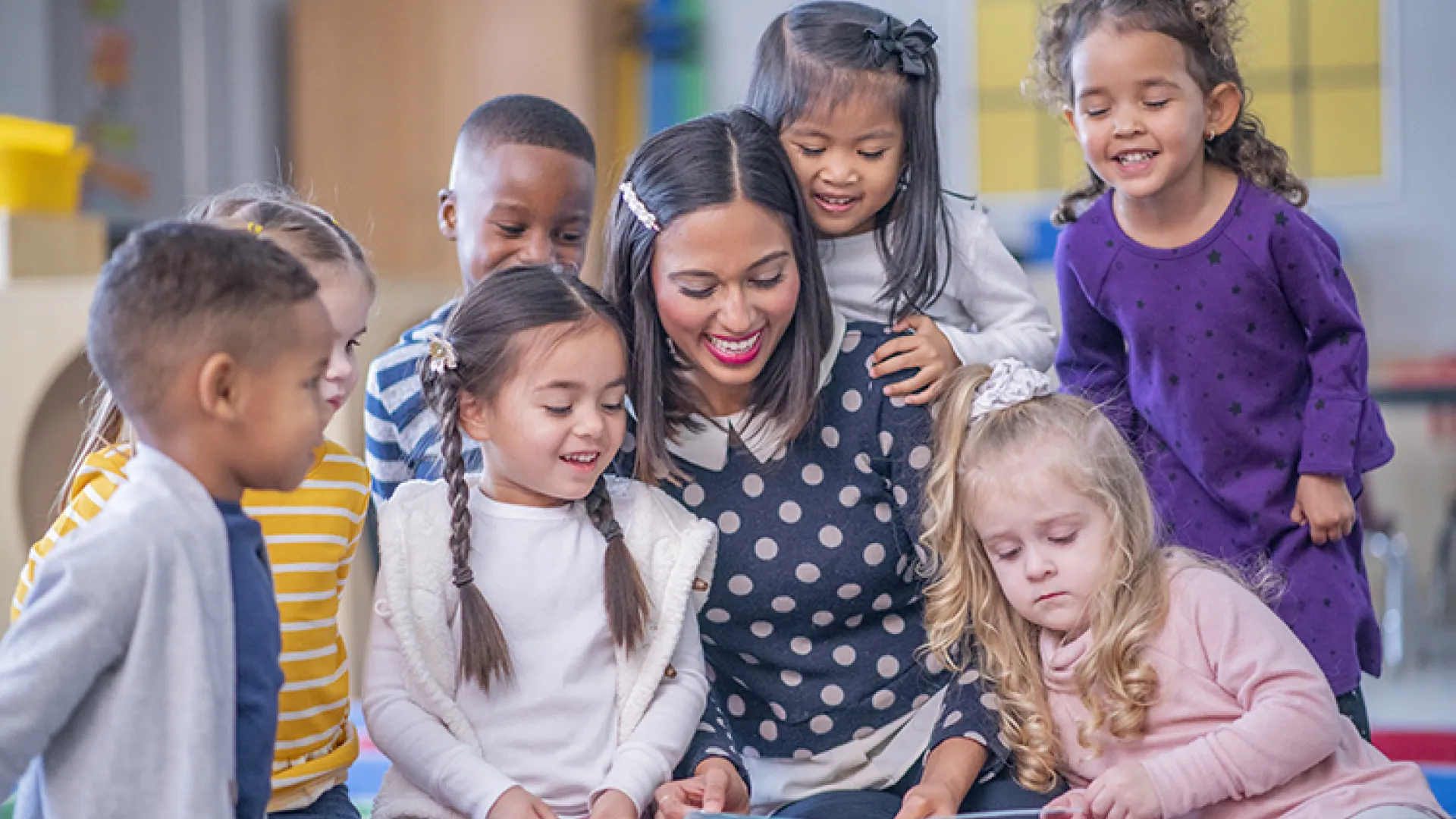 Young students reading with their teacher