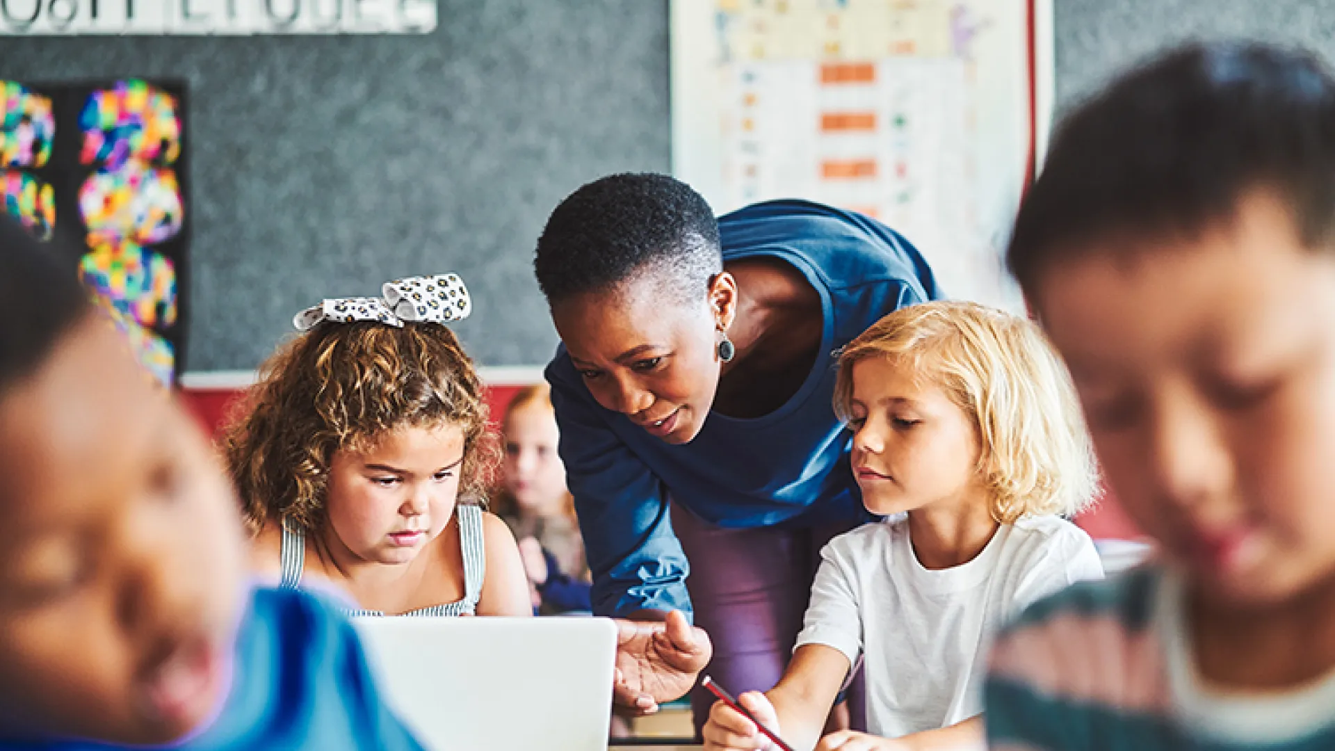 Teacher and young students on computers