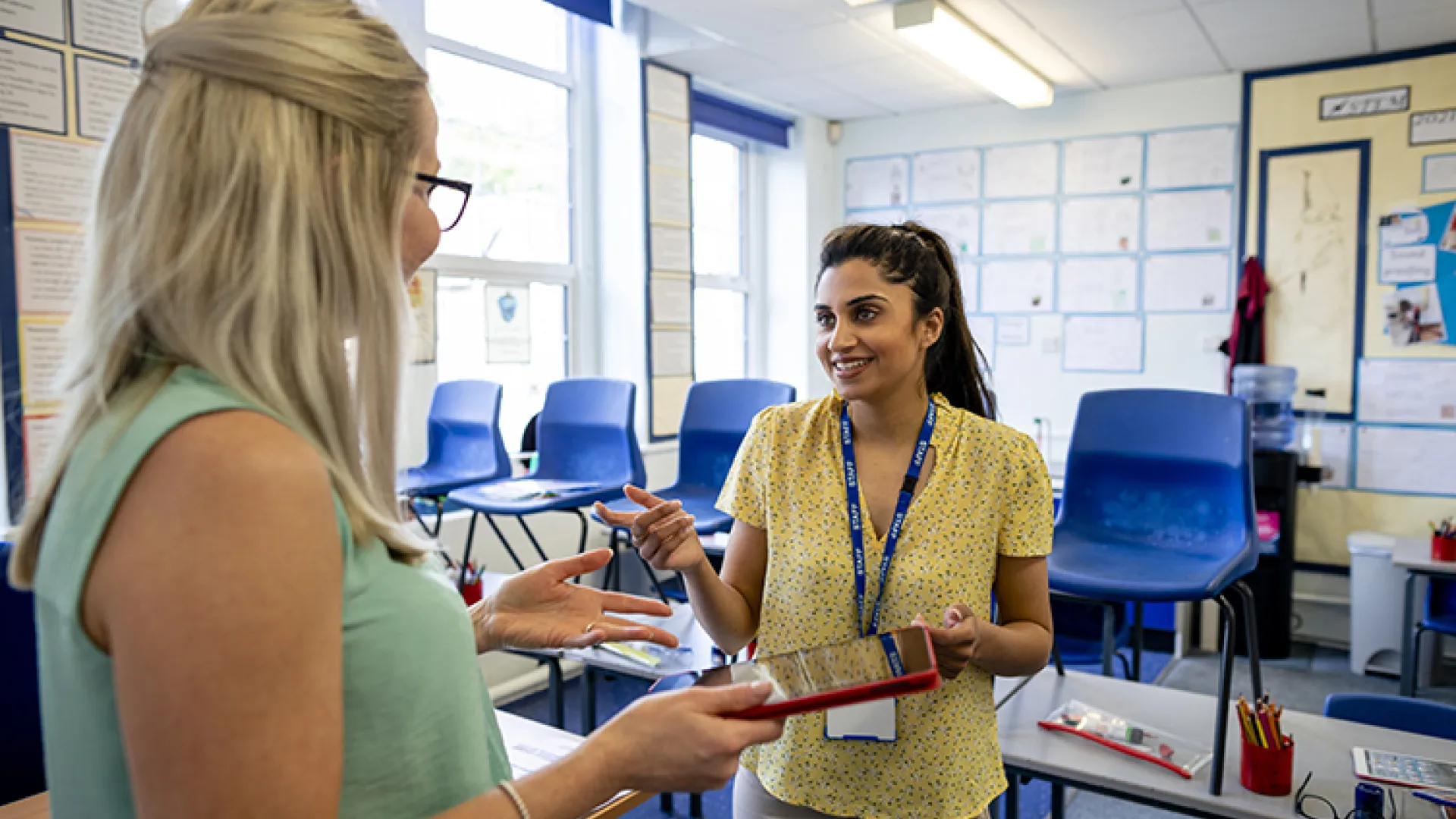 Two teachers talking in a classroom