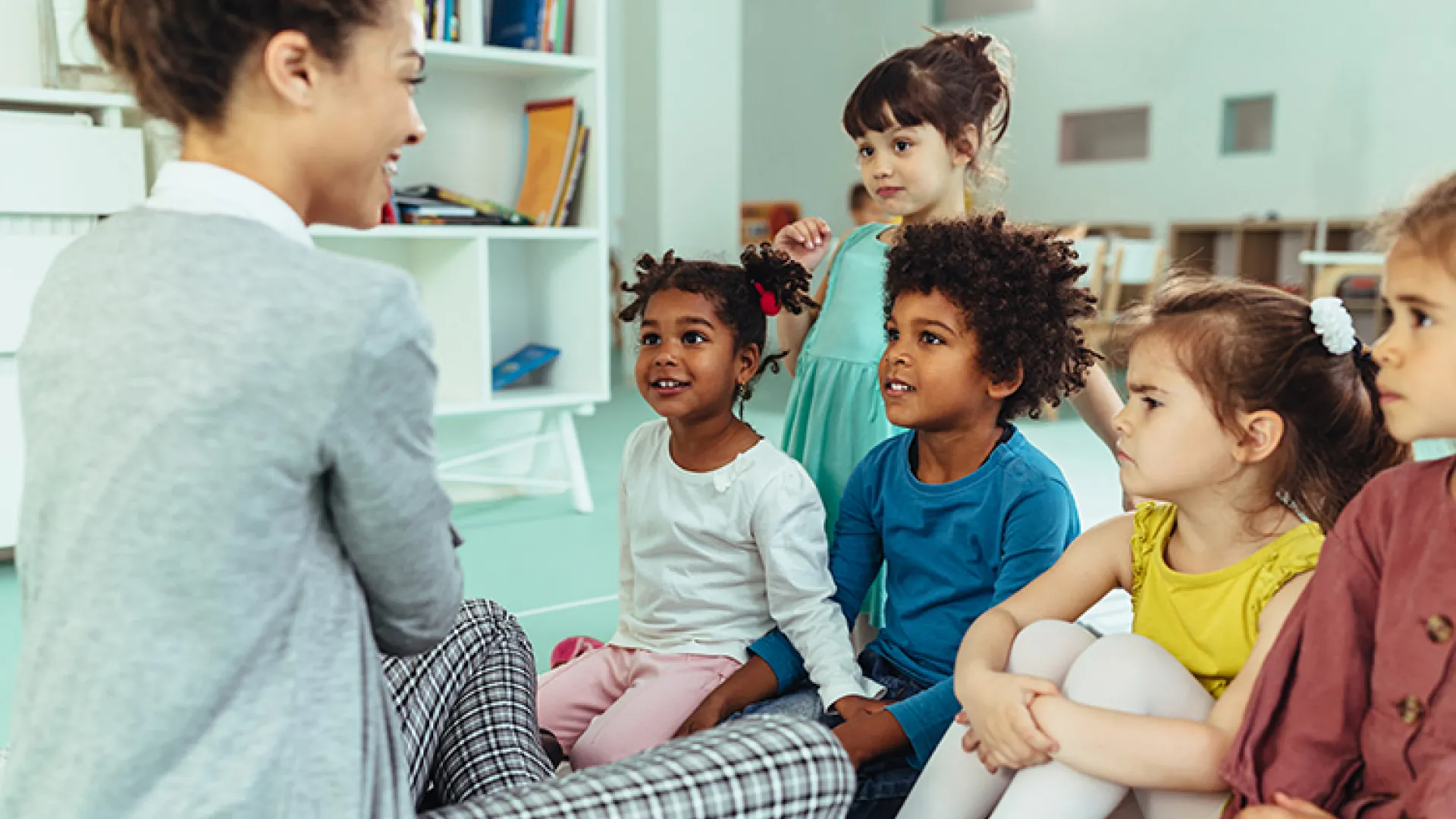 Teacher with young happy diverse students