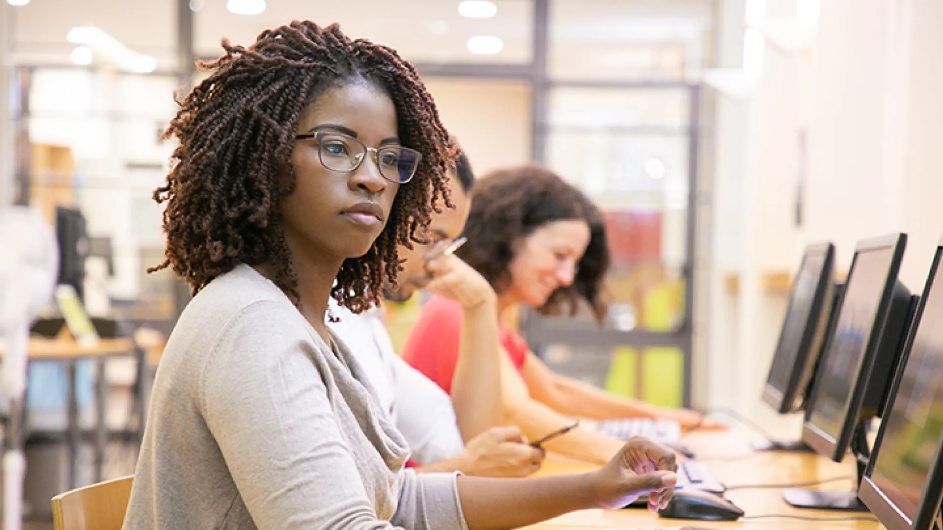 Young woman with glasses at row of computers