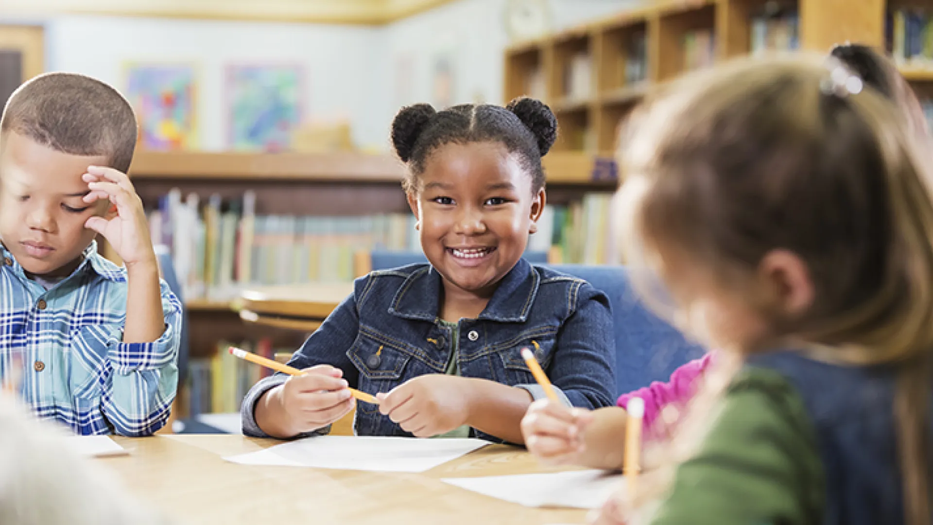 Young elementary students at library table