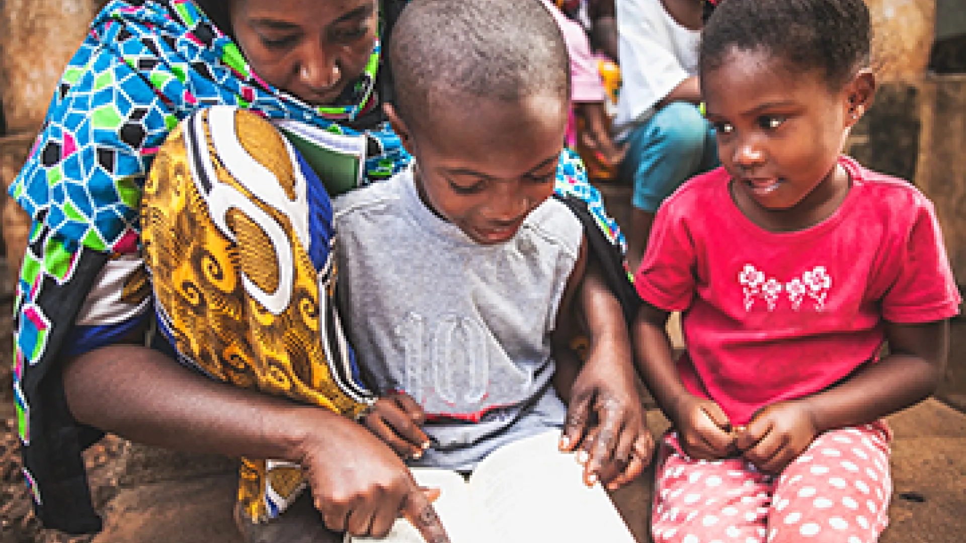 African child doing homework with his mother
