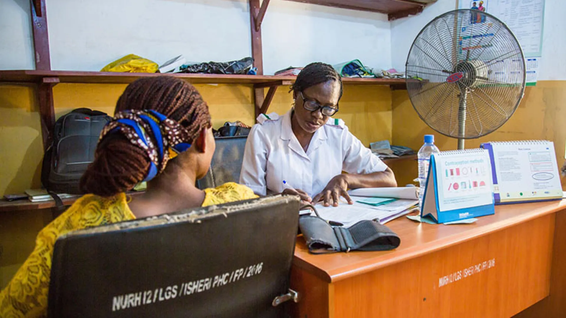African woman at desk in health center