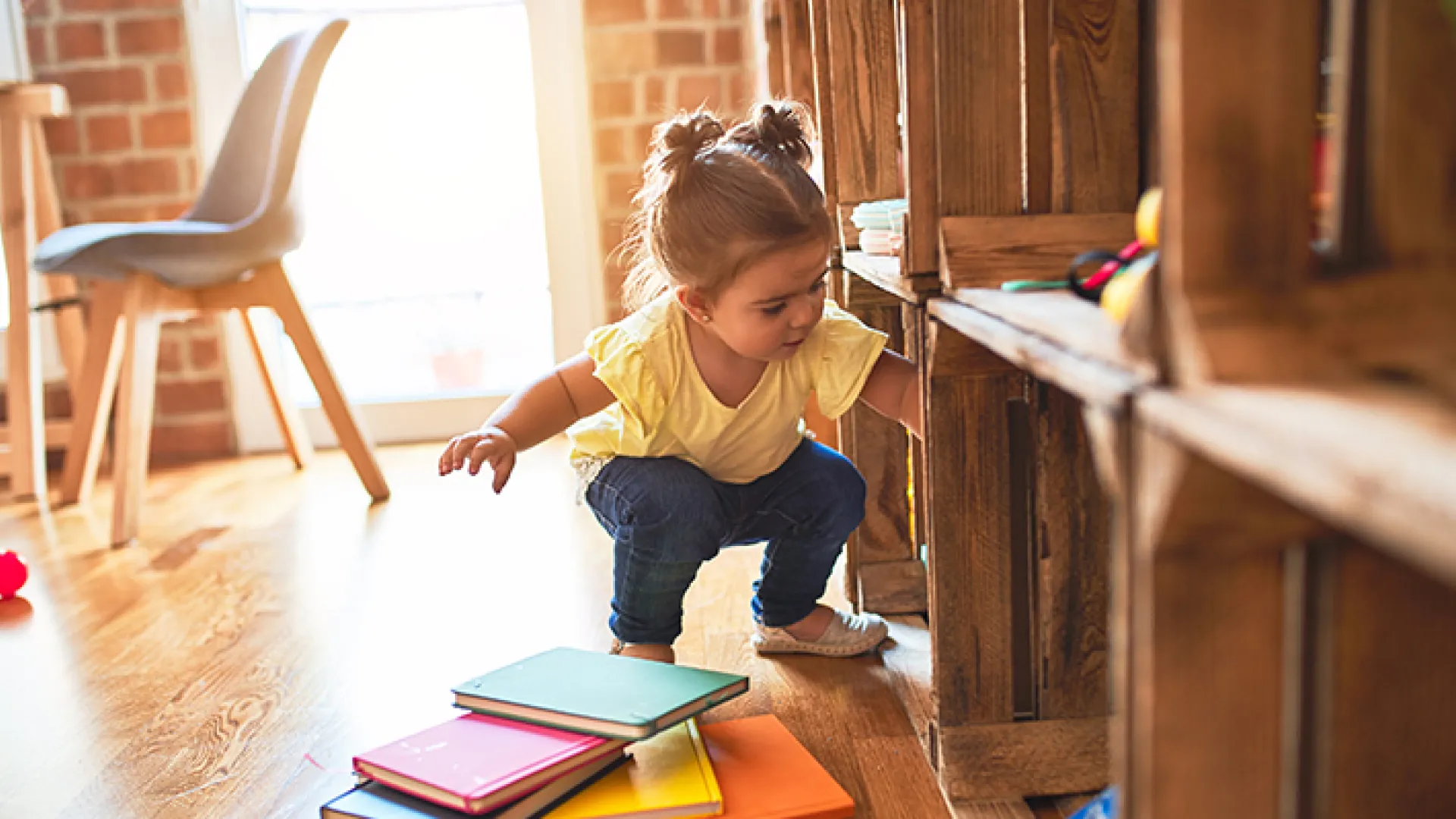 Toddler pulling books off shelves
