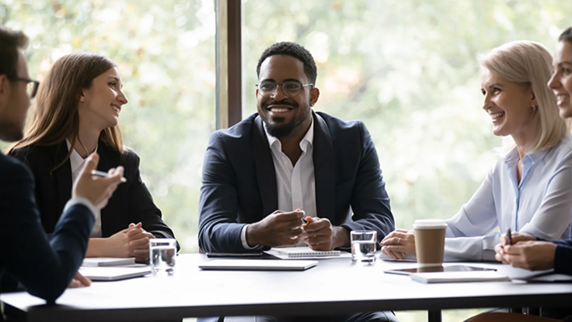 Five multiethnic company staff gather together talking planning future project