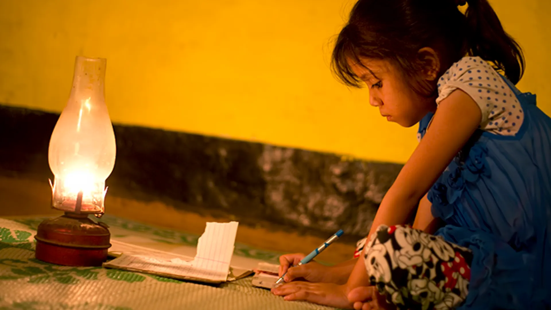 Rural girl studying in lantern light