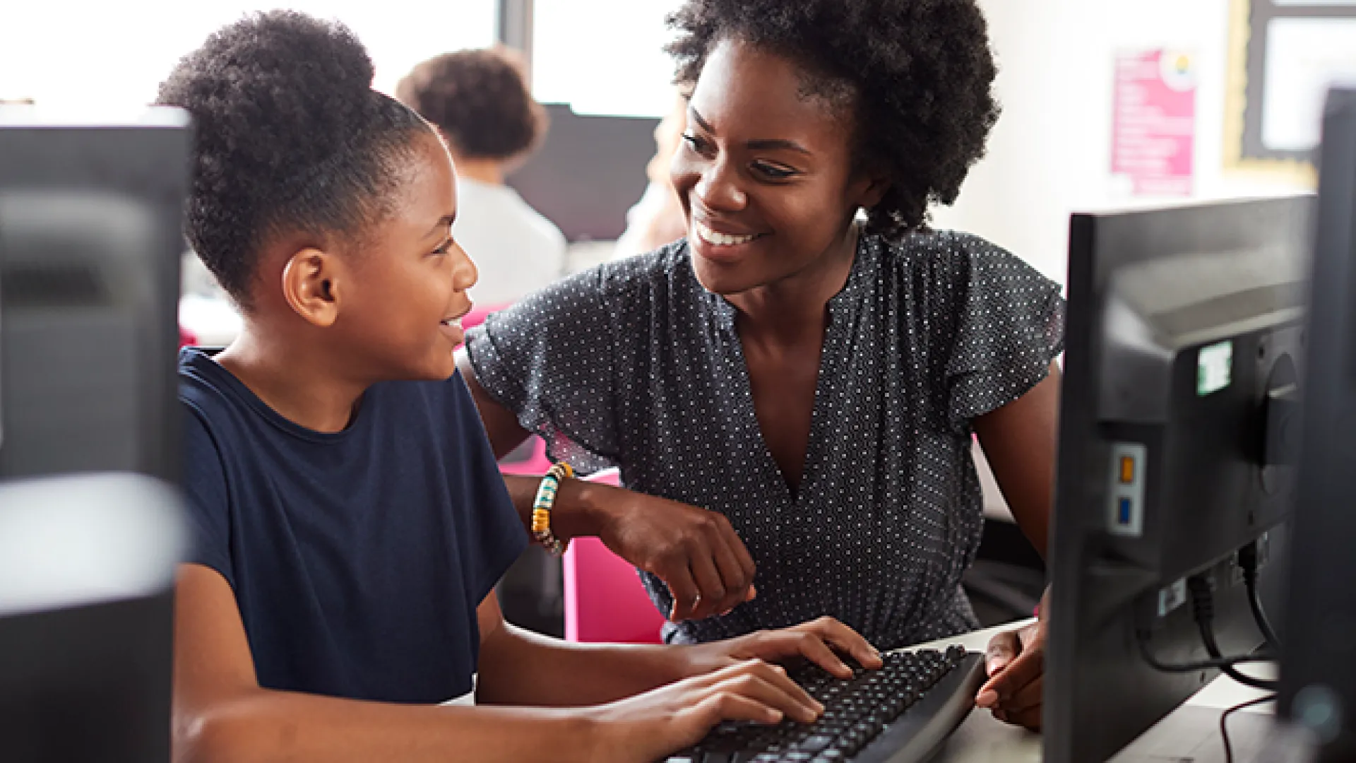 Teacher and student at desktop computer