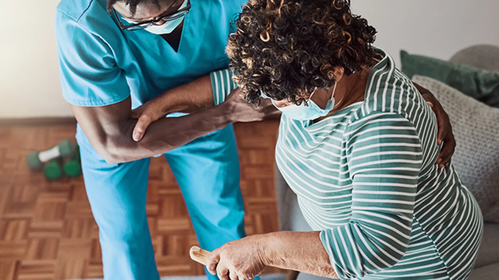 Shot of a young male nurse helping an elderly patient stand