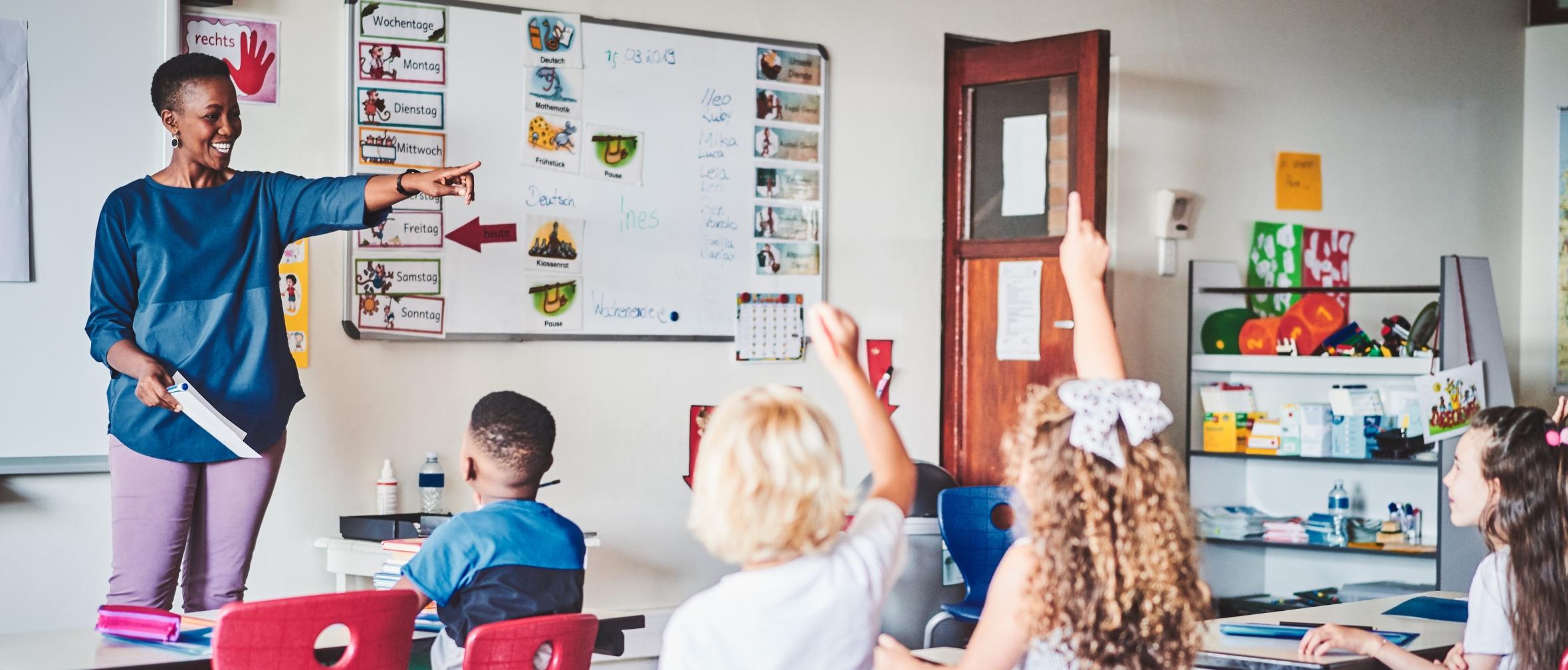 Black teacher calling on elementary students