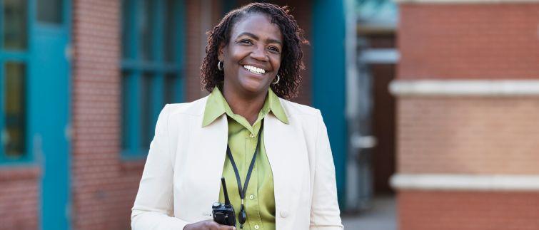 Principal outside a school holding a radio