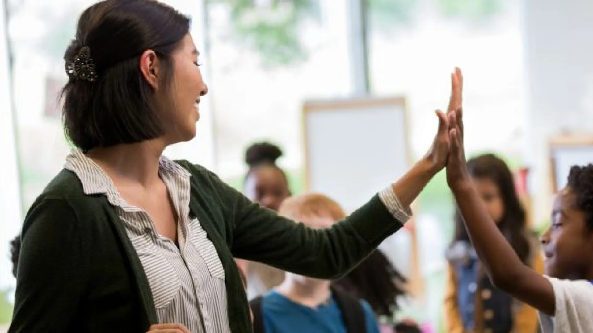Teacher high fives an elementary student