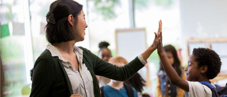 Teacher high fives an elementary student