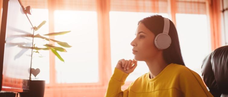 Teacher seated at computer wearing headphones