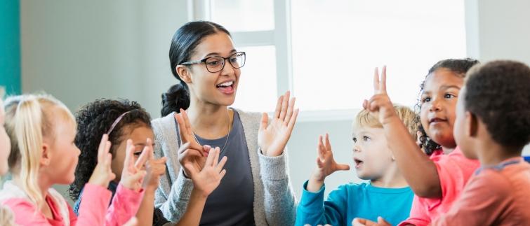 Female teacher clapping hands and counting with elementary students