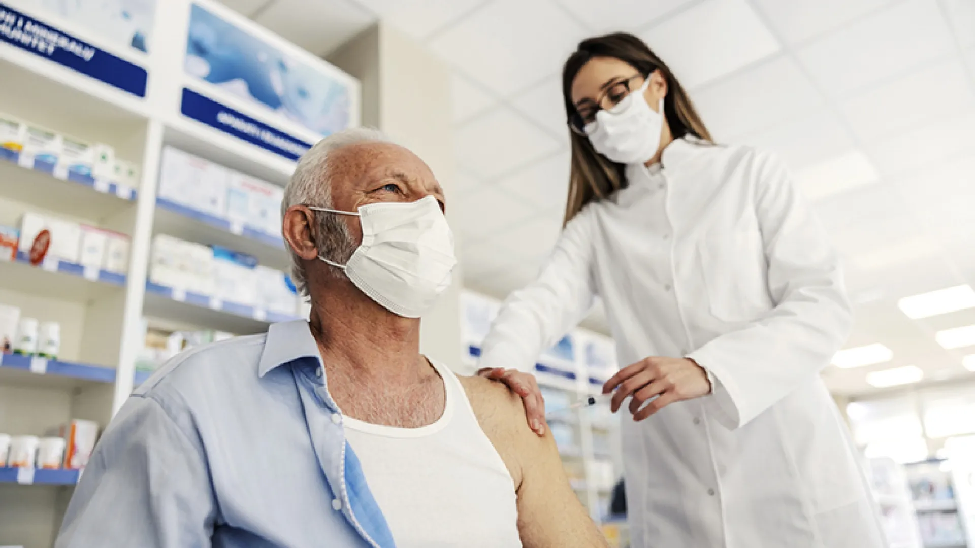Pharmacist giving shot to man