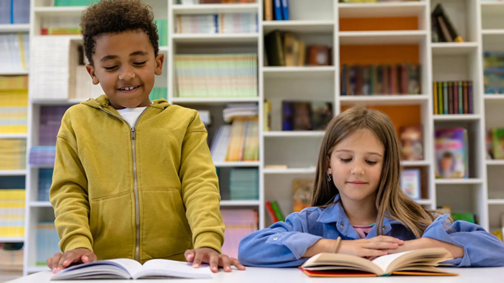 boy and girl elementary students reading together