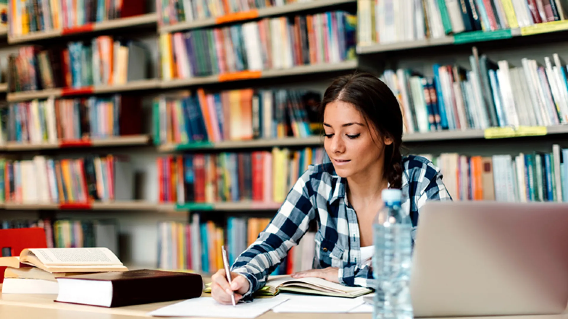 high school student doing schoolwork in library