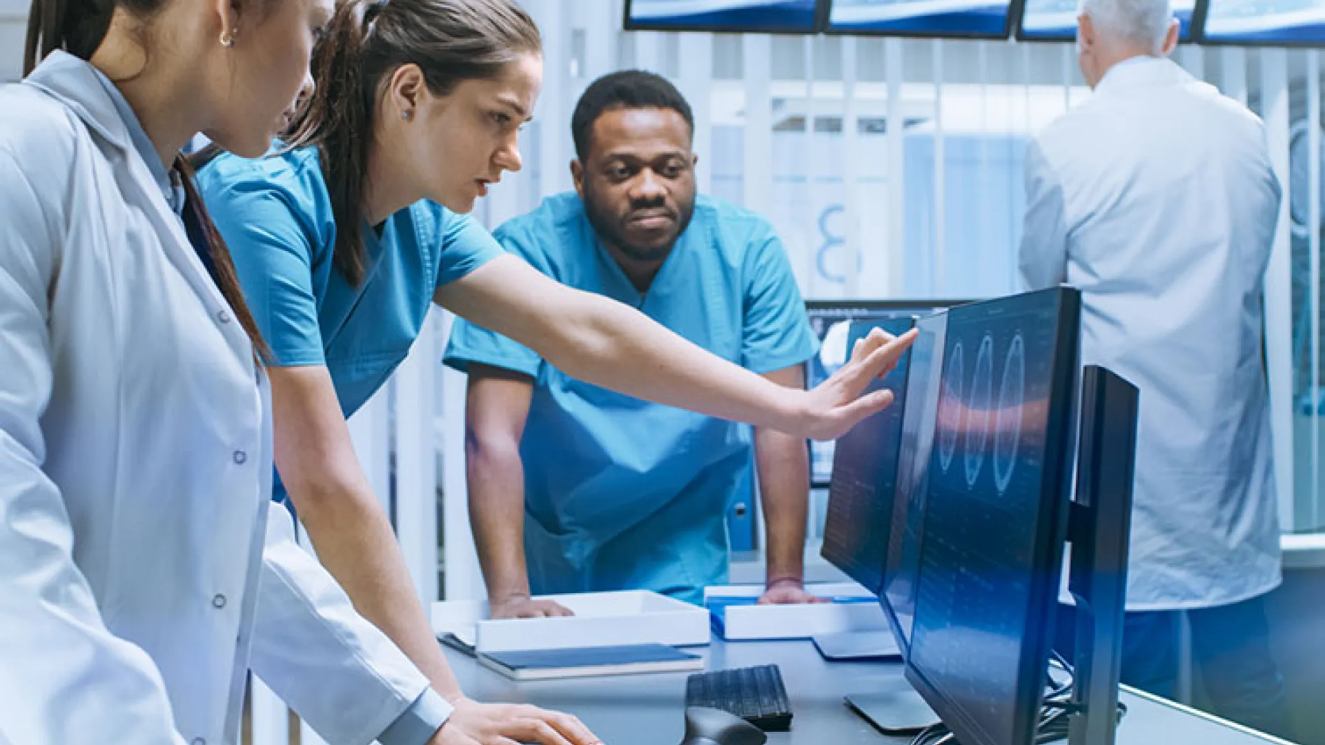 team of healthcare workers looking at computer monitor