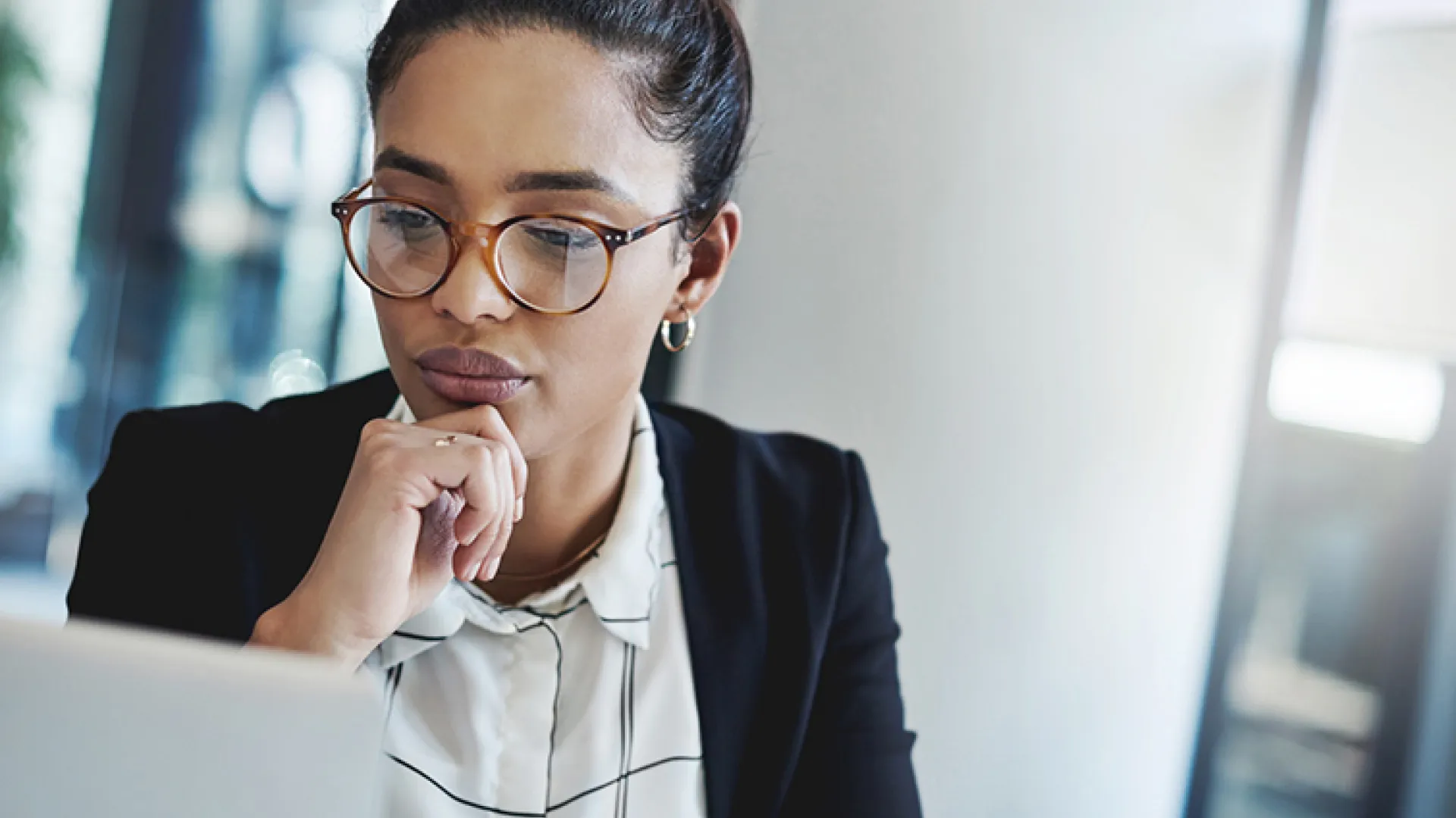 female employee looking thoughtfully at computer