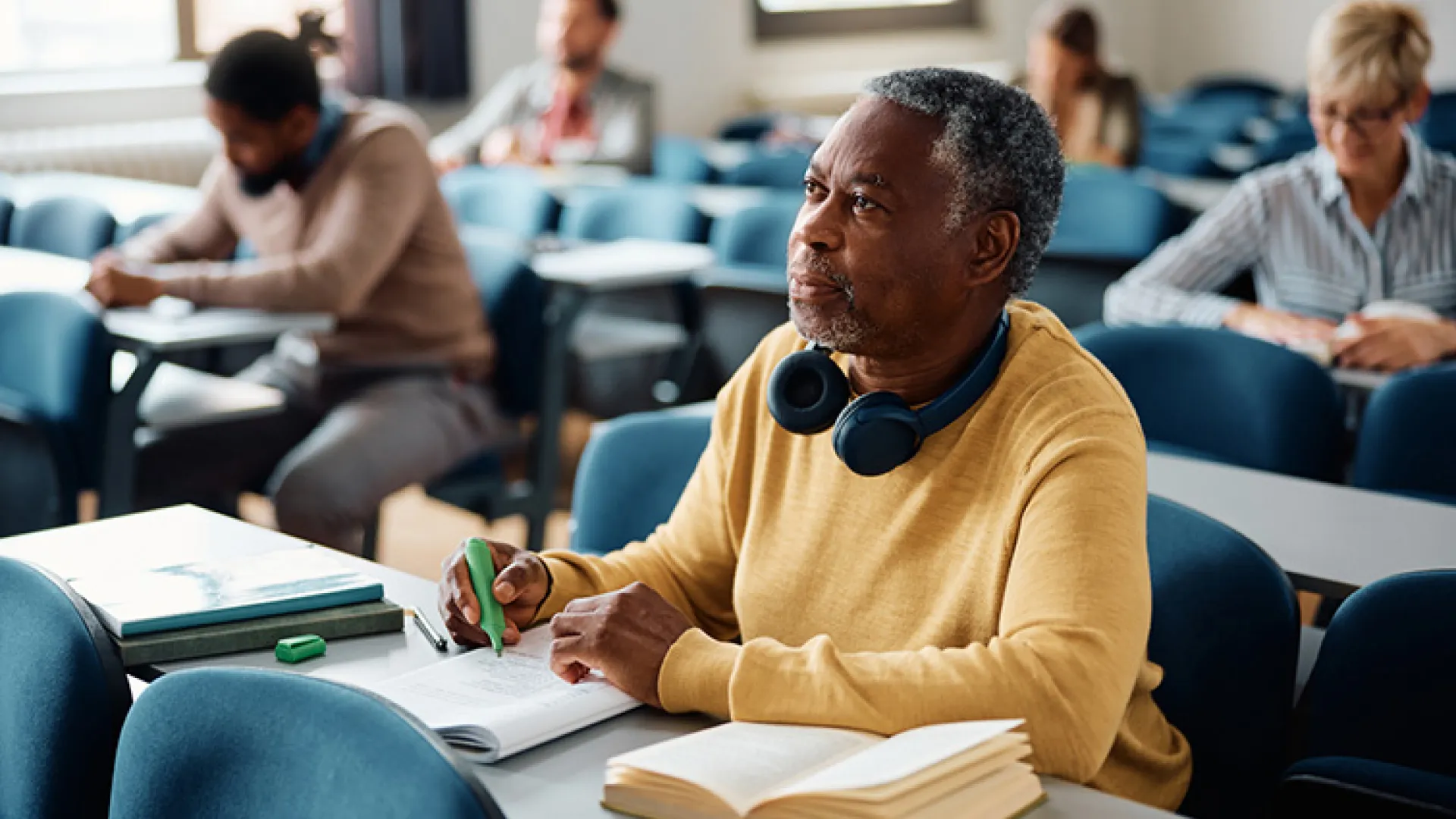 mature adult student taking notes in class
