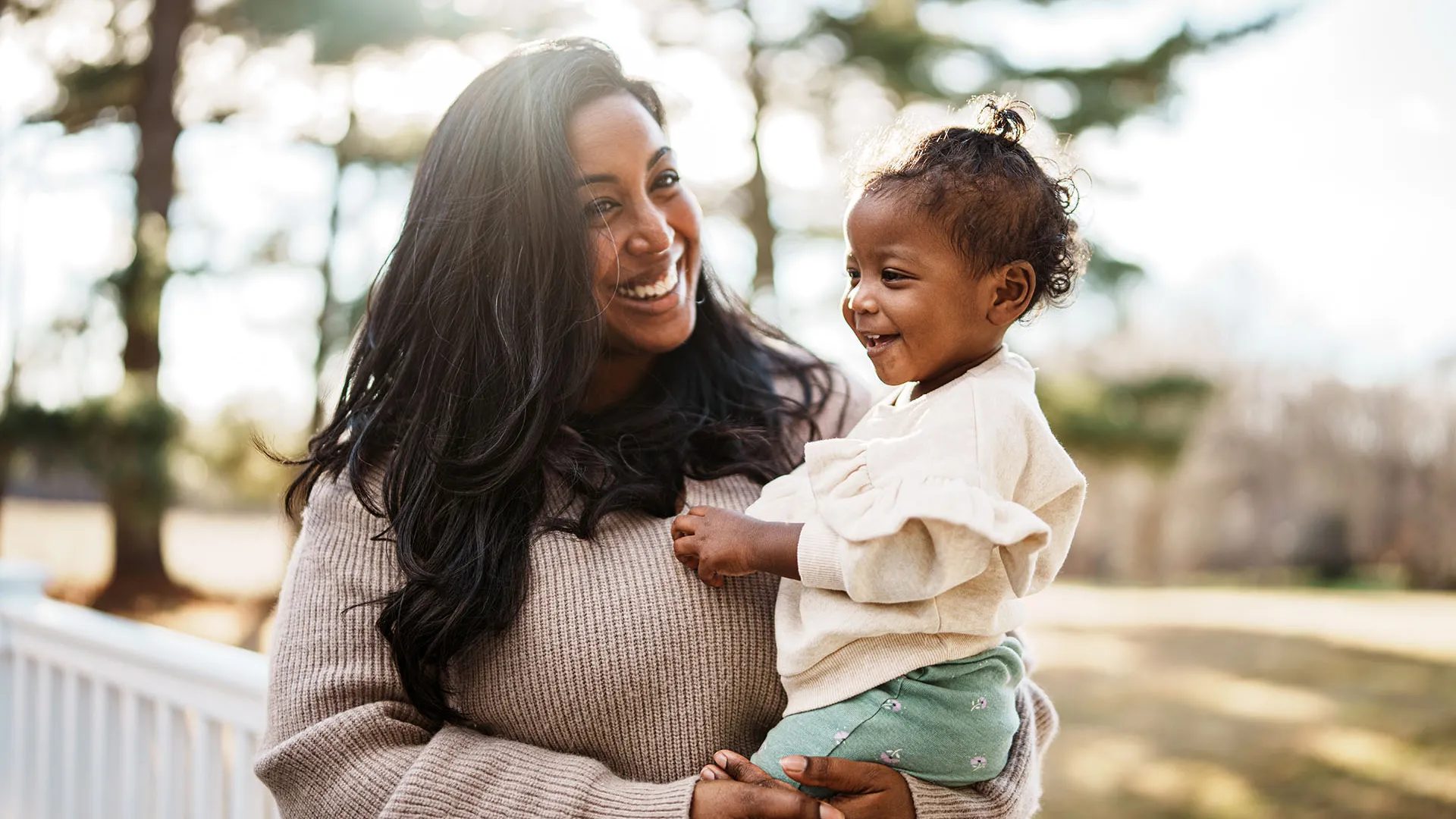 Loving mom holding baby outside