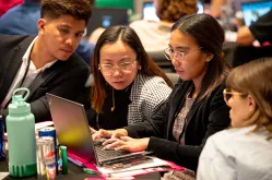 participants in Season of CS event looking at laptop together
