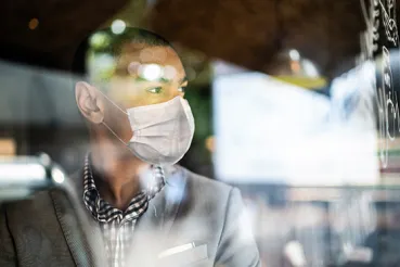 Man in mask looking out the window