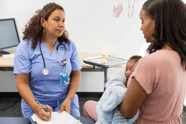 woman with newborn at doctor visit