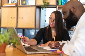 Trainee with disability at laptop with mentor