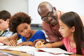 Teacher working with elementary students in classroom