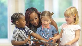 Black teacher with three preK students