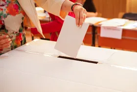 Woman putting ballot in box