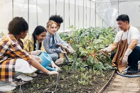 Teens learning about gardening from older adult