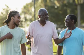 Three African American men walking and talking outside