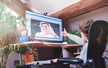 Image of child giving teacher on screen a thumbs up