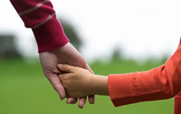 adult and child holding hands