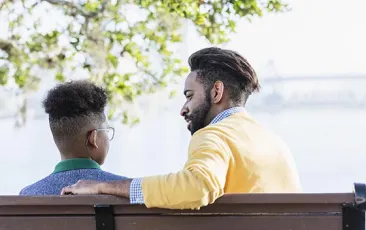 Image of man and school-aged boy on a bench