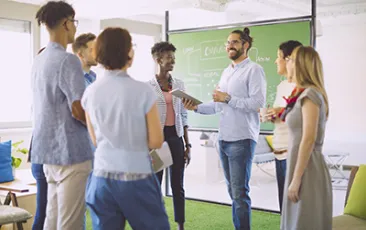Teachers standing by chalkboard talking