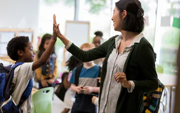 Image of teacher high-fiving a student 