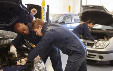 Apprentice working with mechanic