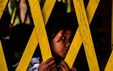 Young girl behind a fence