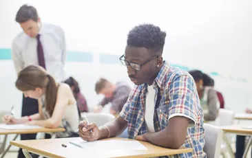 High school student studying at school desk