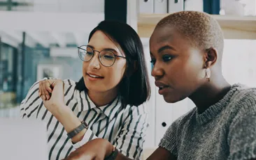 Colleagues work together at a laptop