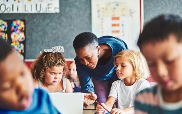 Teacher and young students on computers